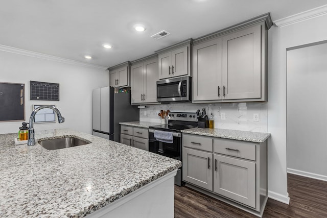 kitchen featuring light stone countertops, appliances with stainless steel finishes, gray cabinetry, and sink