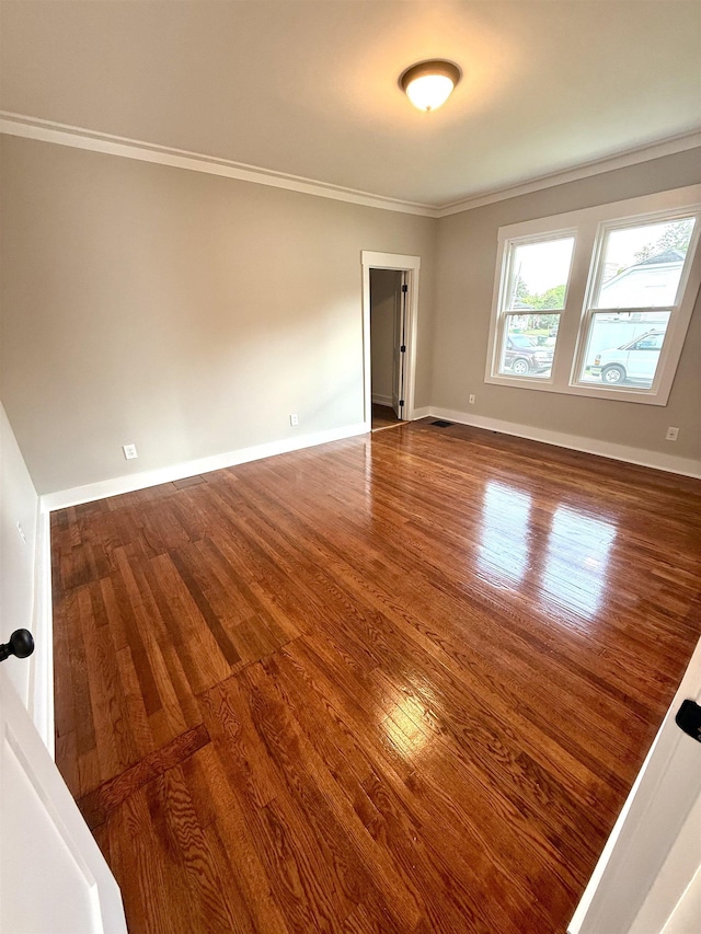  - empty room with baseboards, ornamental molding, and wood finished floors