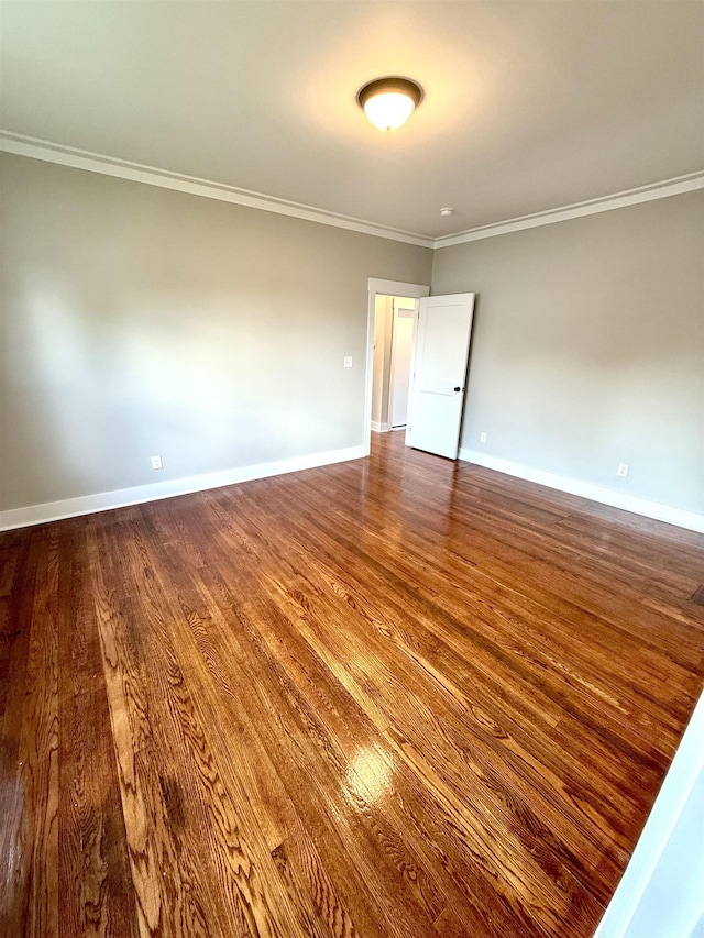  - empty room featuring baseboards, ornamental molding, and wood finished floors