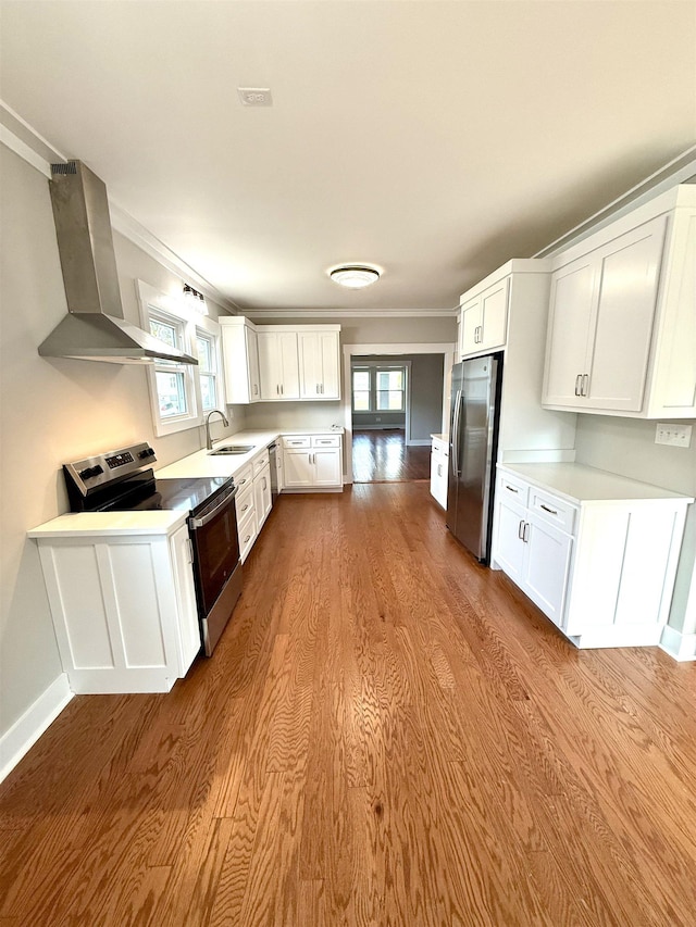  - kitchen with a sink, wall chimney range hood, ornamental molding, and stainless steel appliances