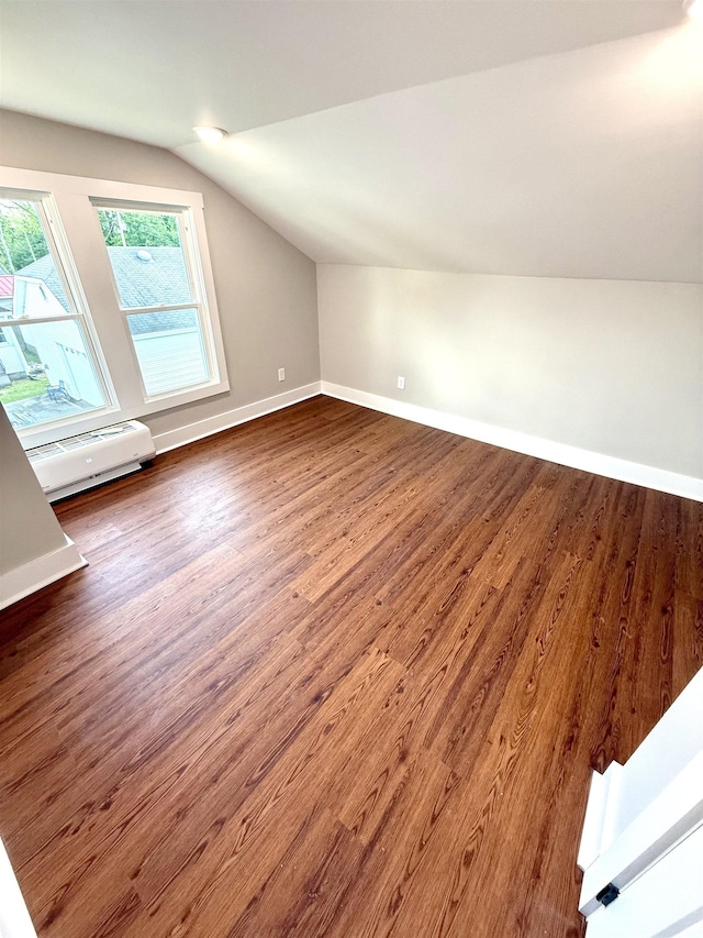  - additional living space featuring baseboards, a baseboard radiator, dark wood-style flooring, and vaulted ceiling