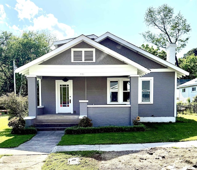 - bungalow-style home with a porch, a chimney, and a front yard