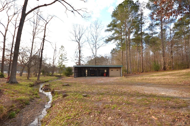 view of front of house featuring a pole building, driveway, and an outdoor structure