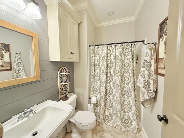 bathroom with toilet, crown molding, sink, and wooden walls