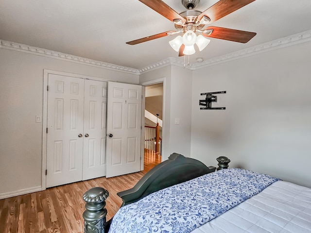 bedroom featuring ornamental molding, a closet, ceiling fan, and hardwood / wood-style flooring