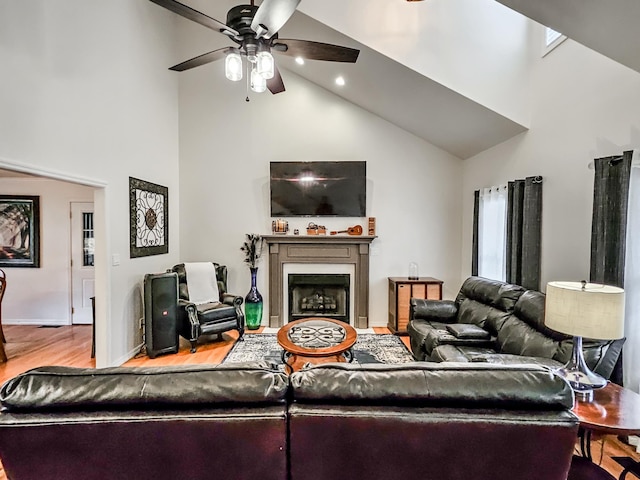 living room featuring light hardwood / wood-style floors, high vaulted ceiling, and ceiling fan