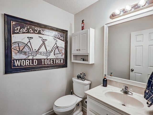 bathroom with vanity, a textured ceiling, and toilet