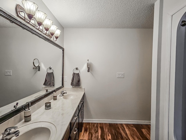 bathroom with vanity, a textured ceiling, and hardwood / wood-style flooring