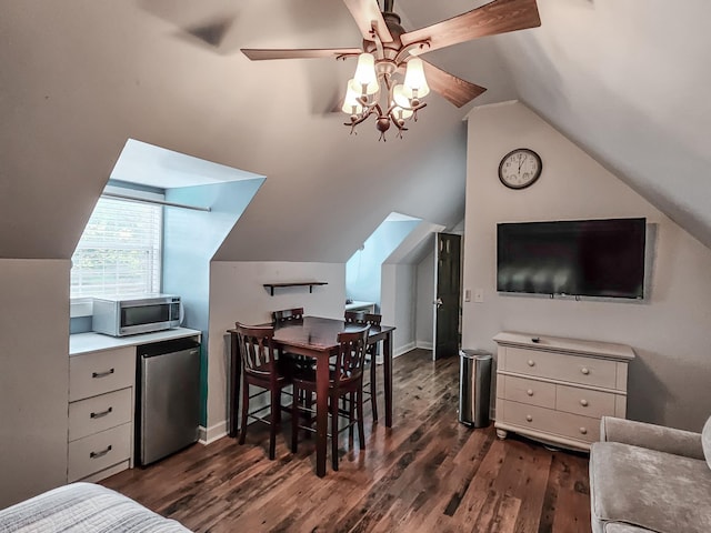 dining area with ceiling fan, dark hardwood / wood-style flooring, and vaulted ceiling