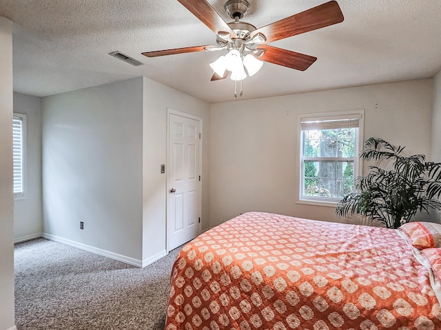 bedroom with carpet flooring, a textured ceiling, and ceiling fan