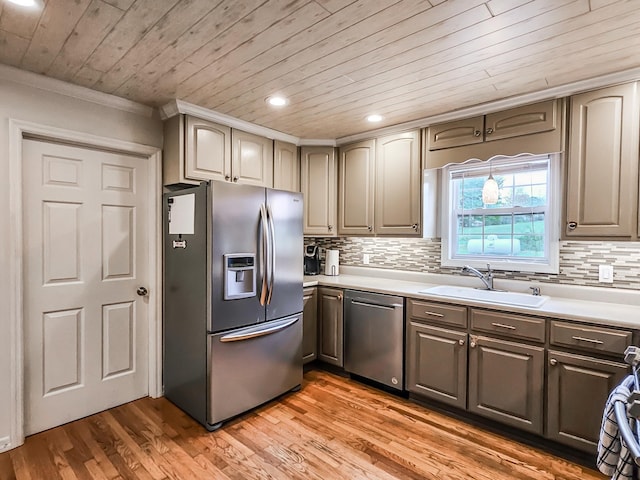 kitchen featuring sink, backsplash, light wood-type flooring, appliances with stainless steel finishes, and ornamental molding