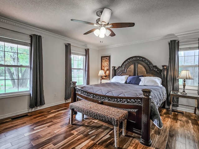 bedroom featuring dark hardwood / wood-style flooring, ceiling fan, crown molding, and a textured ceiling