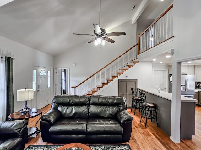 living room featuring beam ceiling, ceiling fan, light hardwood / wood-style flooring, and high vaulted ceiling