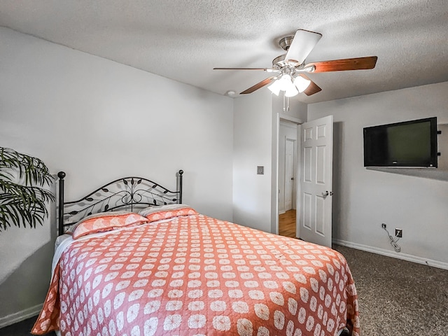 carpeted bedroom featuring ceiling fan and a textured ceiling