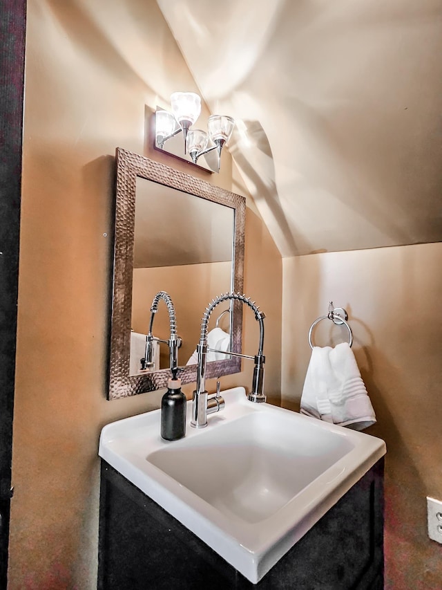 bathroom with vanity, lofted ceiling, and an inviting chandelier