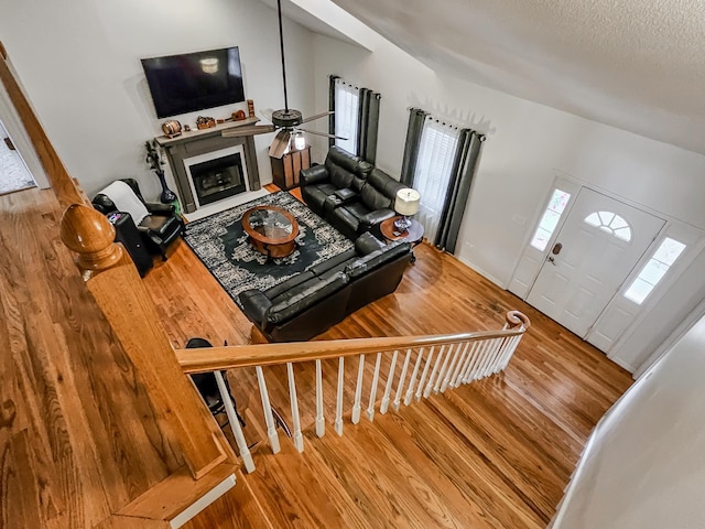 living room featuring lofted ceiling, a textured ceiling, and hardwood / wood-style flooring