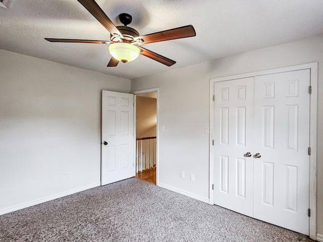 unfurnished bedroom featuring ceiling fan, carpet floors, a textured ceiling, and a closet