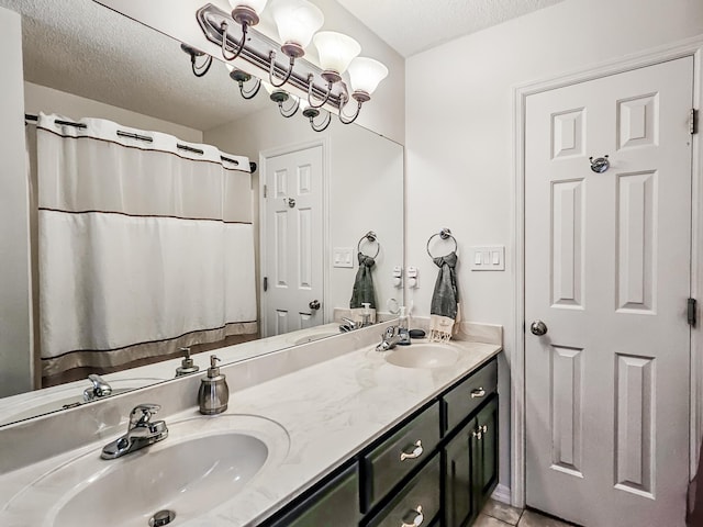 bathroom featuring tile patterned floors, vanity, and a textured ceiling