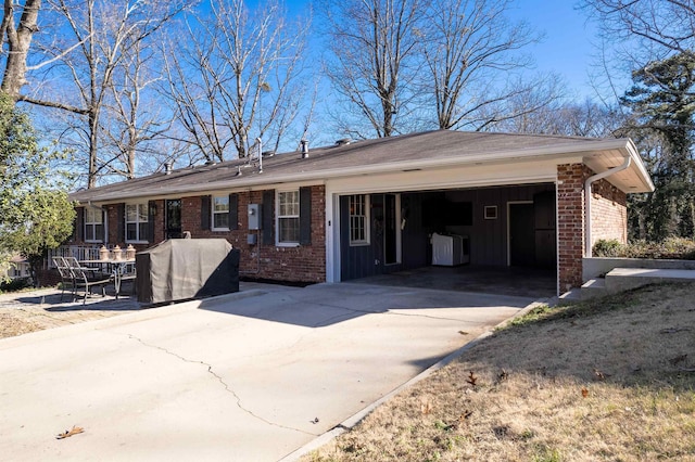 view of front of property with an attached garage, driveway, board and batten siding, and brick siding