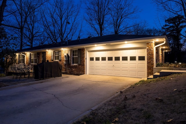 single story home with stone siding, driveway, and an attached garage