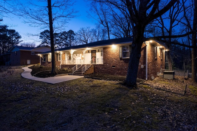 single story home with covered porch, brick siding, and crawl space