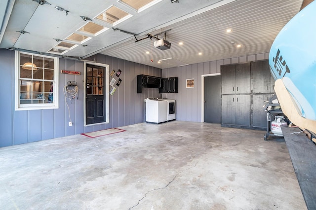 garage with washing machine and dryer and a garage door opener