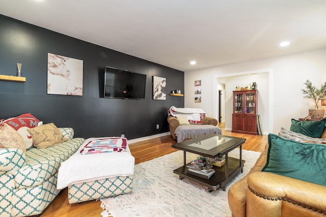 living area featuring baseboards, wood finished floors, and recessed lighting