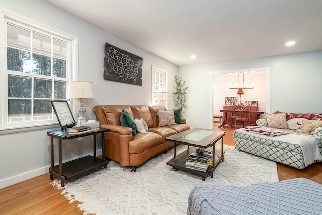 living area with a notable chandelier, recessed lighting, wood finished floors, and baseboards