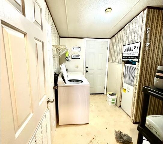  - laundry room with separate washer and dryer, a heating unit, and wallpapered walls