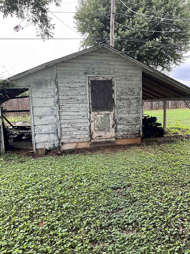 view of outdoor structure featuring a yard and a carport