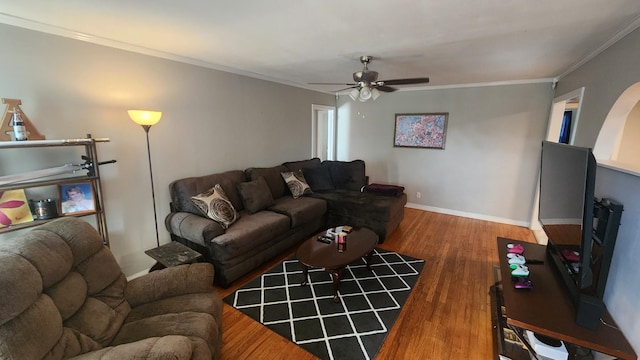 living room with hardwood / wood-style flooring, ceiling fan, and crown molding