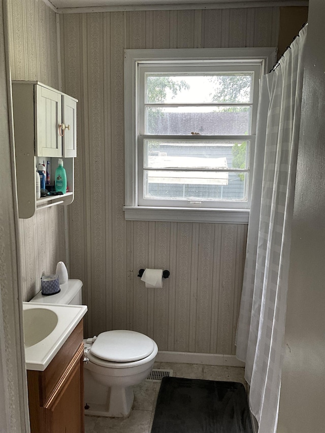 bathroom with tile patterned flooring, vanity, wood walls, and toilet