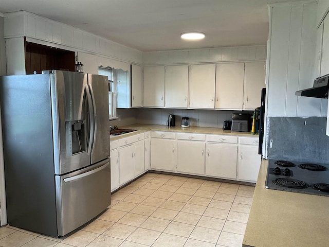 kitchen with white cabinetry, stainless steel fridge with ice dispenser, light tile patterned floors, and electric stovetop