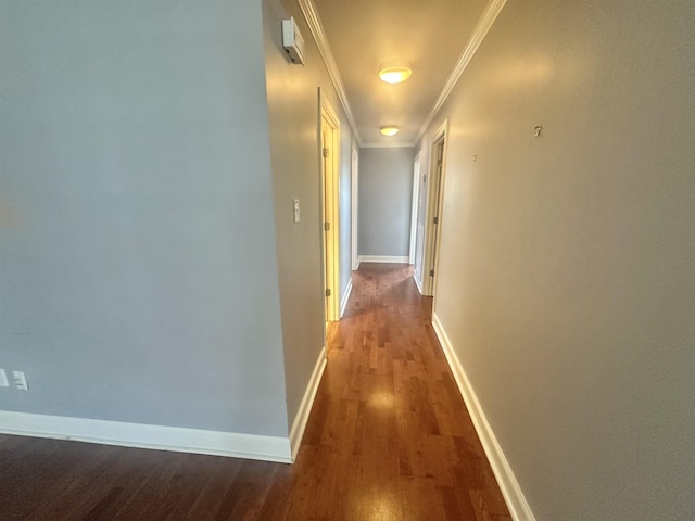  - corridor featuring wood finished floors, ornamental molding, and baseboards