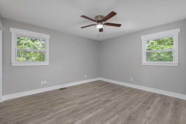  - unfurnished room featuring healthy amount of natural light, wood finished floors, and ceiling fan