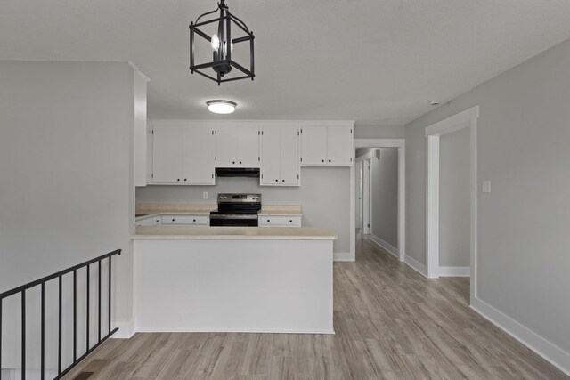  - kitchen featuring stainless steel range with electric stovetop, light countertops, light wood-style floors, a peninsula, and under cabinet range hood