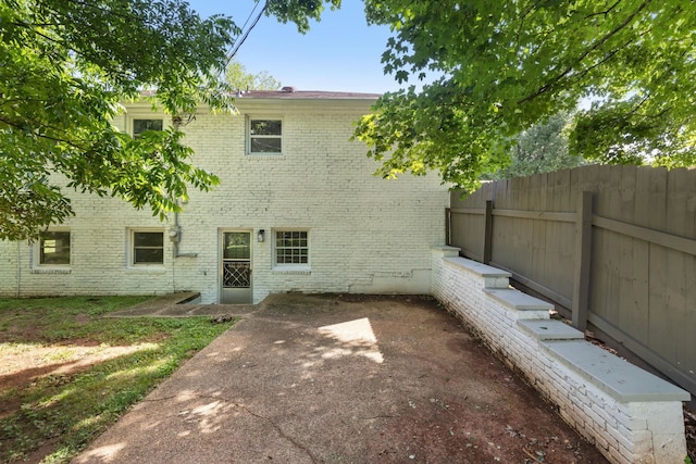  - back of house featuring brick siding and a patio area