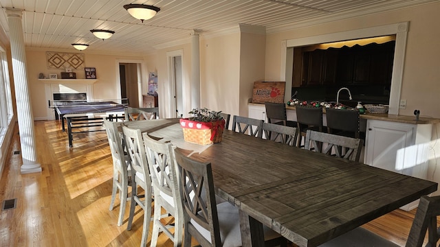 dining area featuring light wood-type flooring, visible vents, and crown molding