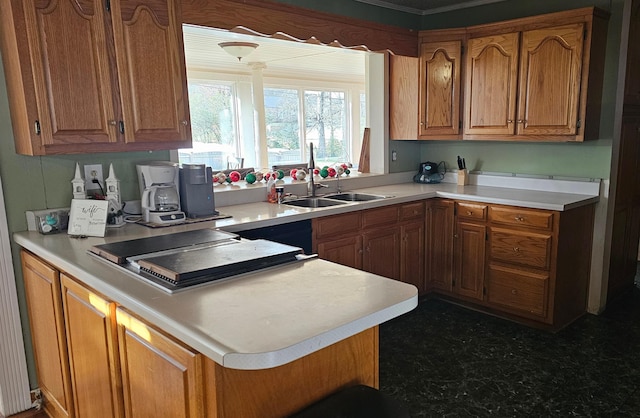 kitchen featuring light countertops, brown cabinets, and a sink