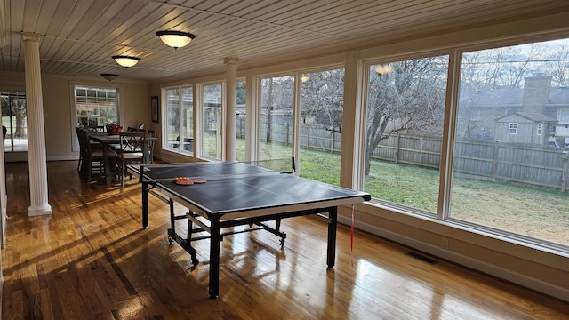 rec room featuring hardwood / wood-style floors, decorative columns, visible vents, and a healthy amount of sunlight