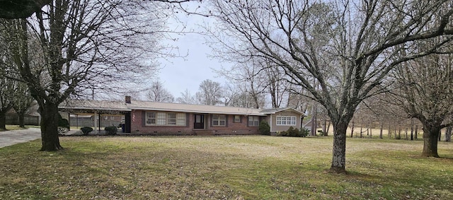 ranch-style house featuring a chimney, crawl space, an attached garage, a front yard, and brick siding