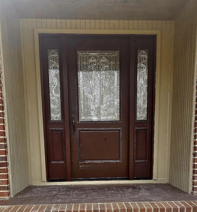 entrance to property featuring brick siding