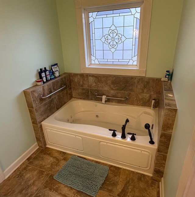 full bath featuring a jetted tub and baseboards