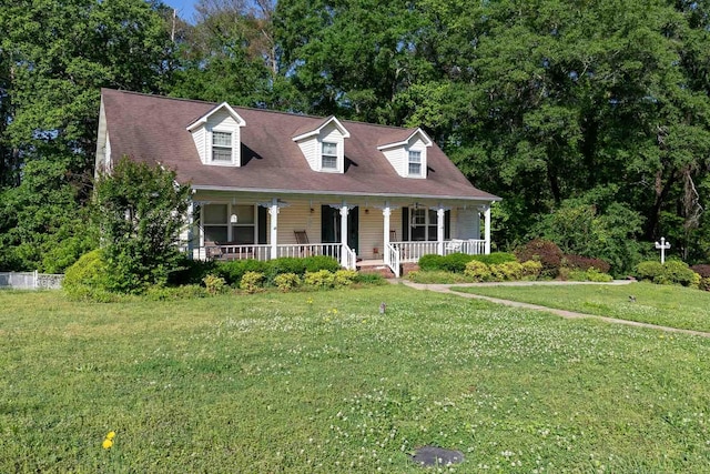 cape cod house featuring covered porch and a front yard