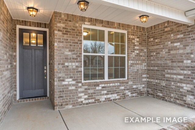 property entrance featuring brick siding