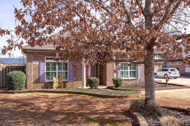 obstructed view of property with fence and brick siding