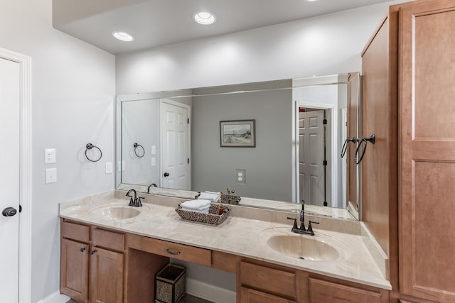 full bathroom with double vanity, a sink, and recessed lighting