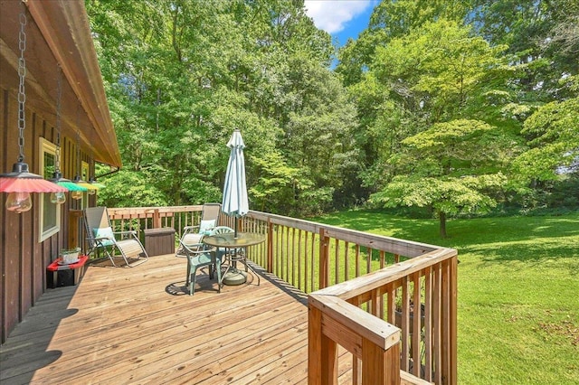 - deck with outdoor dining space and a lawn
