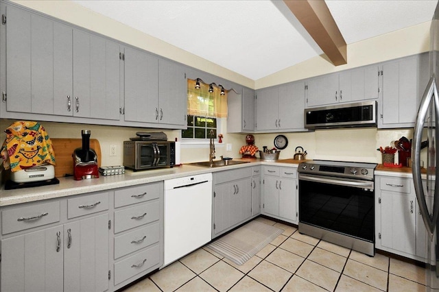  - kitchen with stainless steel appliances, gray cabinetry, light tile patterned floors, and light countertops