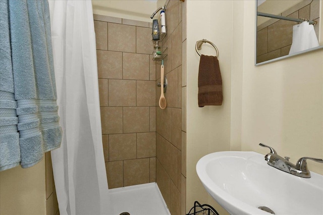  - full bath featuring a sink and a tile shower